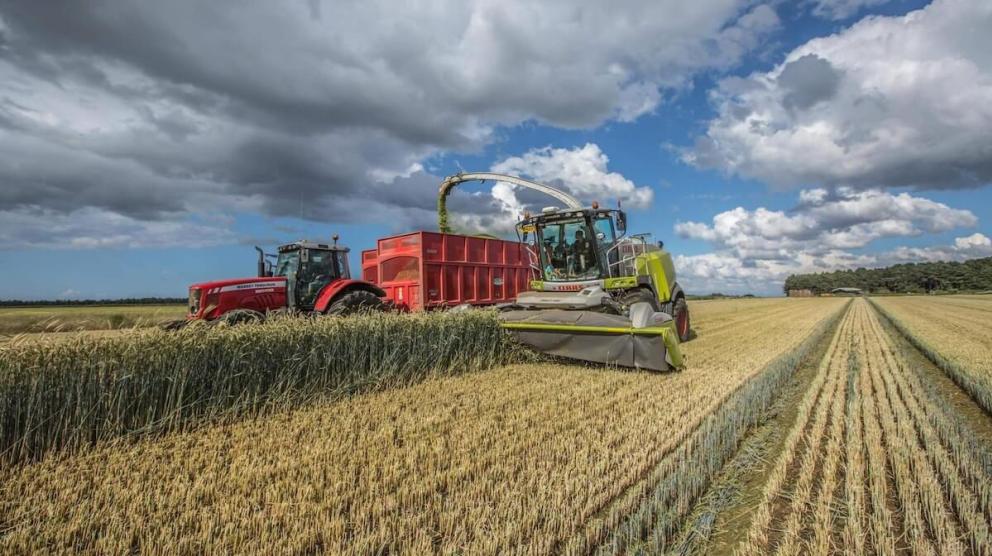 Combine and tractor in field